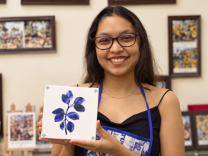 Participant showcasing her finished Azulejo tile painting at CIPA in Panjim, Goa